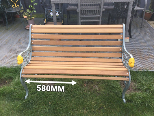 Wooden bench with metal frame on grass, measurement label indicating width of 580mm.